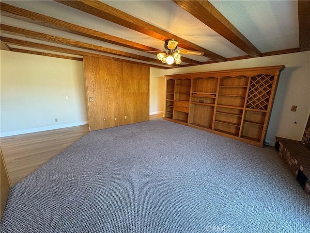 carpeted living room featuring ceiling fan and beam ceiling