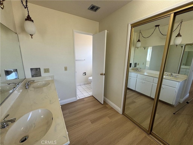 bathroom with toilet, hardwood / wood-style flooring, and vanity