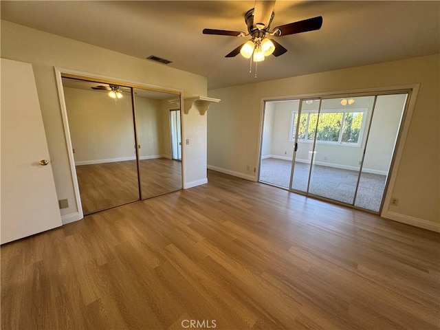 unfurnished bedroom with ceiling fan and light wood-type flooring