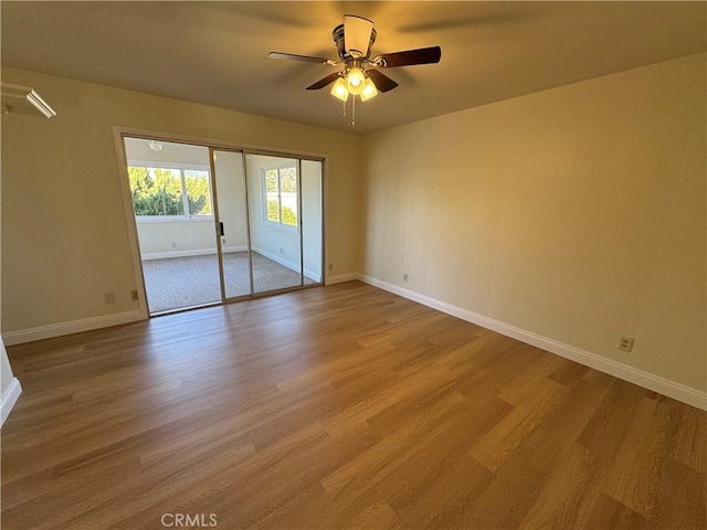 empty room with ceiling fan and light hardwood / wood-style floors