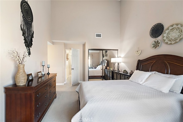 carpeted bedroom with a towering ceiling