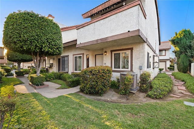 view of front of home with a front lawn and central AC unit