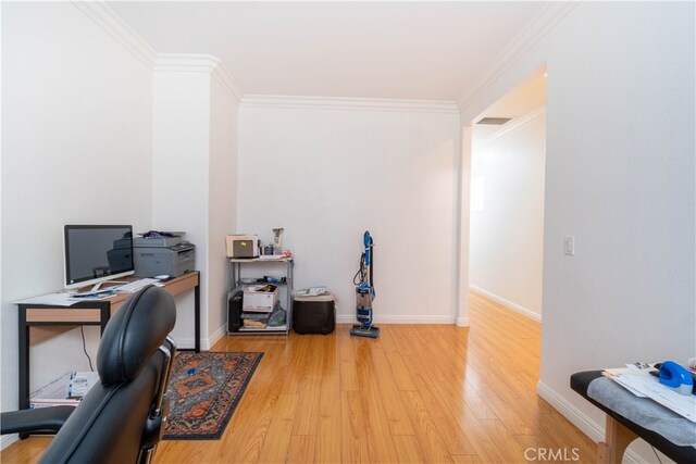 home office with ornamental molding and light hardwood / wood-style floors