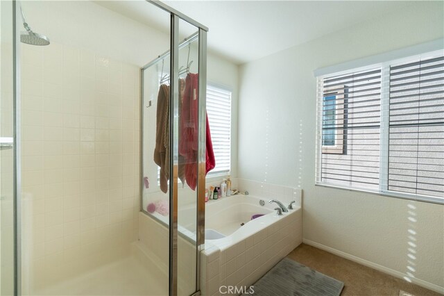 bathroom with shower with separate bathtub and a wealth of natural light