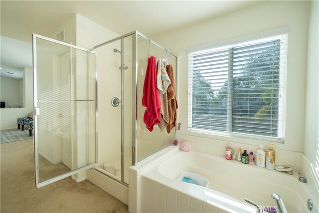 bathroom featuring shower with separate bathtub and a healthy amount of sunlight