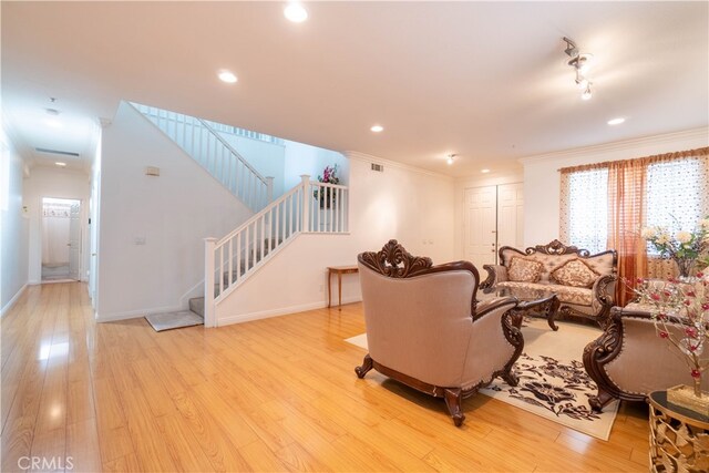 living room with ornamental molding and light wood-type flooring