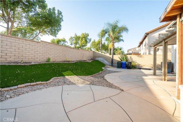 view of yard with central AC and a patio area