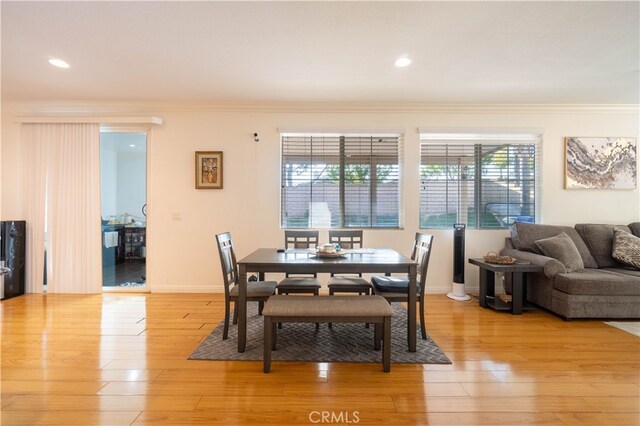 dining area featuring light hardwood / wood-style flooring and crown molding