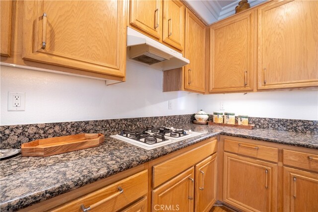 kitchen featuring dark stone countertops and white gas cooktop