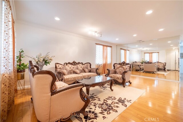 living room with light wood-type flooring and ornamental molding