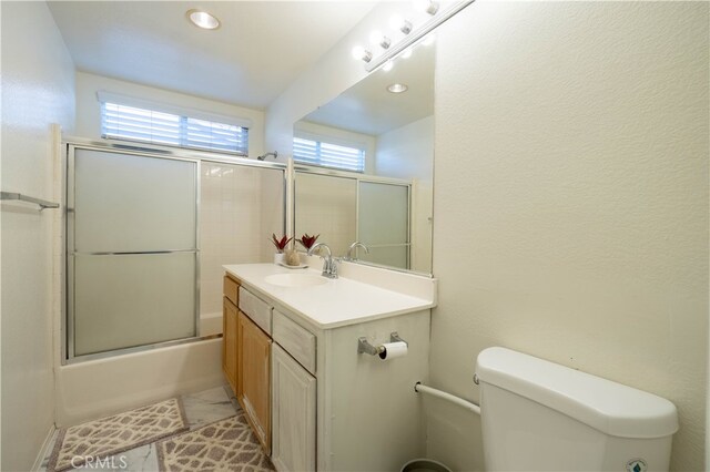 full bathroom with enclosed tub / shower combo, tile patterned flooring, vanity, and toilet