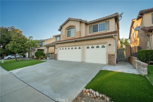 mediterranean / spanish home featuring a front lawn and a garage