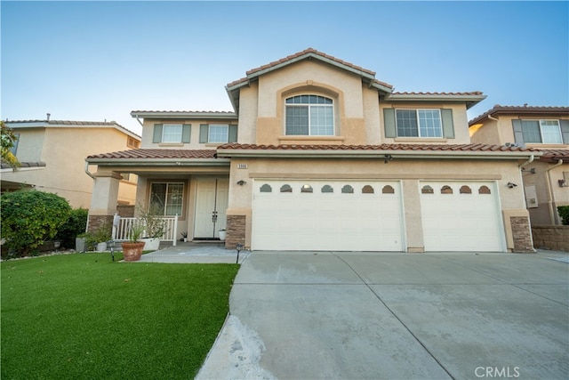 mediterranean / spanish home with a garage, a porch, and a front lawn