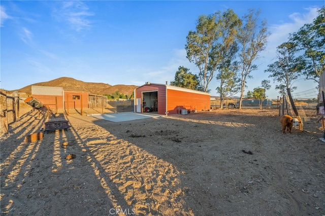 back of property with an outdoor structure and a mountain view