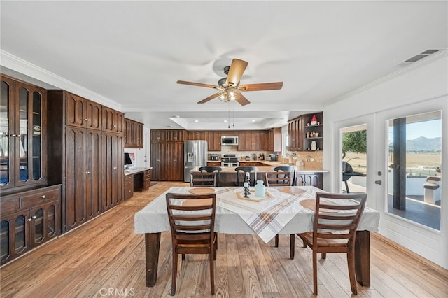 dining room featuring crown molding, ceiling fan, and light hardwood / wood-style flooring