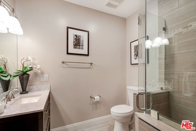 bathroom with vanity, toilet, an enclosed shower, and hardwood / wood-style flooring