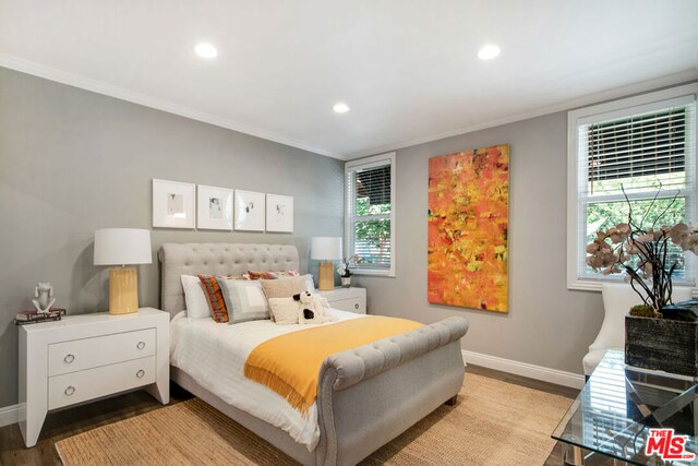 bedroom with ornamental molding, wood-type flooring, and multiple windows