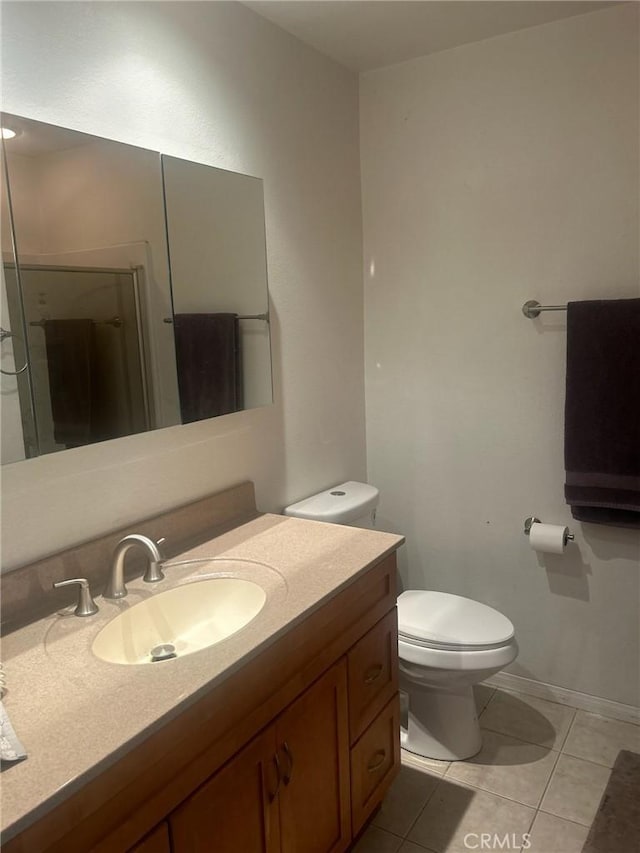 bathroom with tile patterned flooring, vanity, a shower with door, and toilet