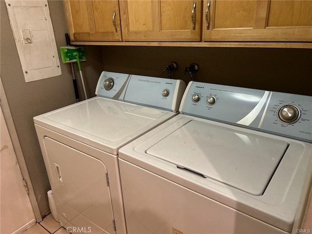 washroom with electric panel, light tile patterned floors, cabinets, and independent washer and dryer