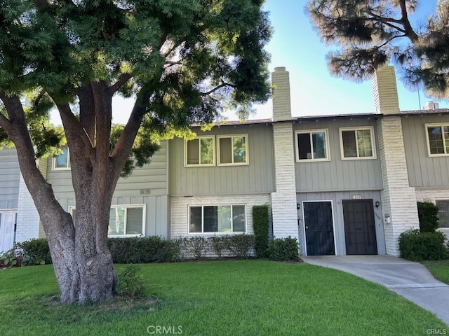 multi unit property with a front yard and a garage