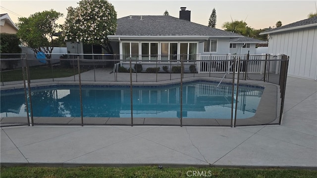 pool at dusk featuring a patio area