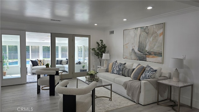 living room featuring crown molding and light hardwood / wood-style floors