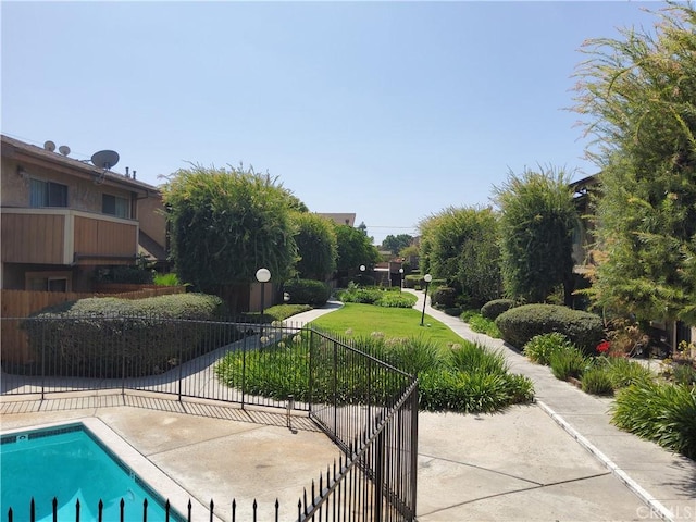 view of property's community with a lawn and a swimming pool