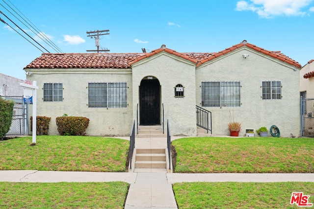 mediterranean / spanish home with a front lawn