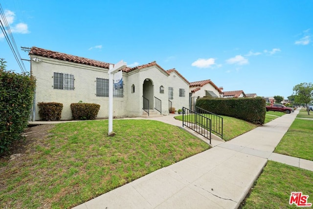 mediterranean / spanish-style house featuring a front lawn