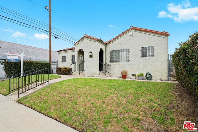 mediterranean / spanish home with a front lawn