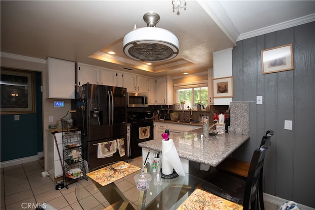 kitchen featuring sink, kitchen peninsula, white cabinetry, black appliances, and a tray ceiling