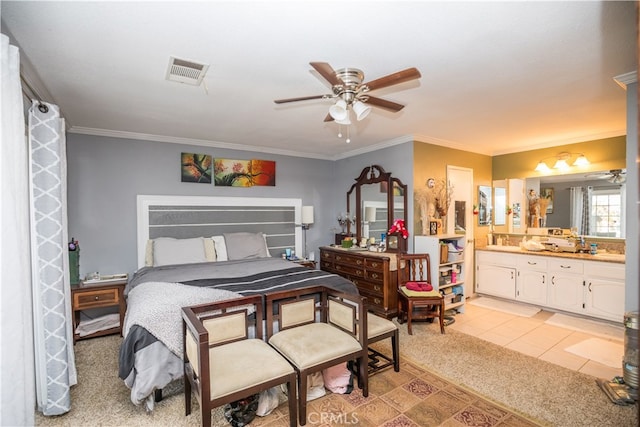 bedroom featuring ceiling fan, light colored carpet, ensuite bath, and crown molding