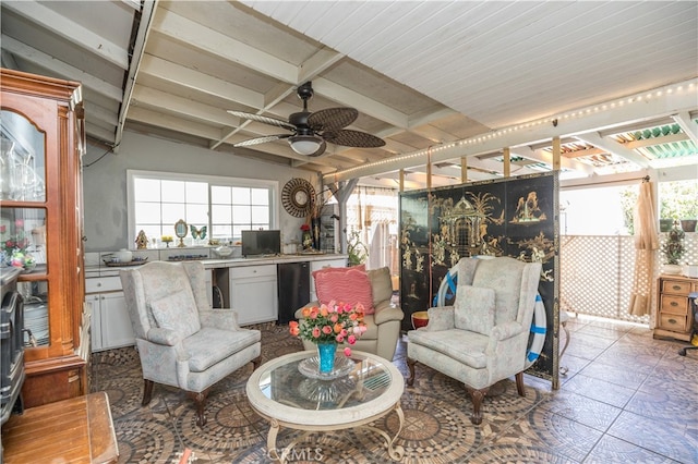 interior space with lofted ceiling with beams and ceiling fan