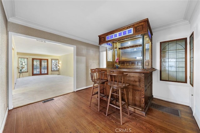 bar with dark hardwood / wood-style flooring and crown molding