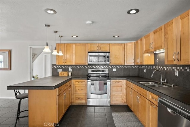 kitchen featuring sink, a kitchen breakfast bar, tasteful backsplash, pendant lighting, and appliances with stainless steel finishes