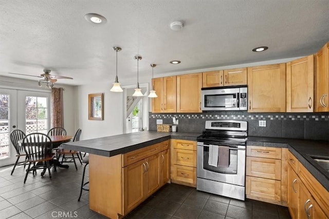 kitchen with a breakfast bar, tasteful backsplash, decorative light fixtures, kitchen peninsula, and stainless steel appliances