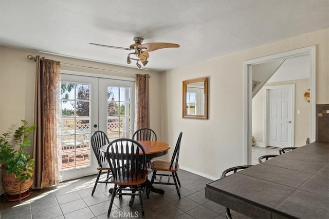 tiled dining room with ceiling fan and french doors