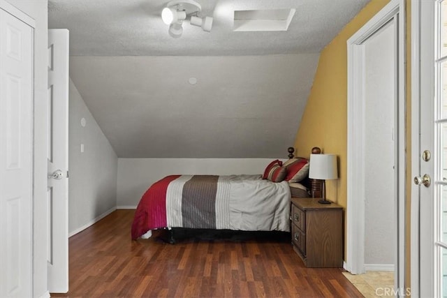 bedroom with dark hardwood / wood-style floors and lofted ceiling