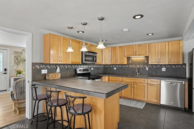 kitchen with kitchen peninsula, tasteful backsplash, stainless steel appliances, sink, and pendant lighting