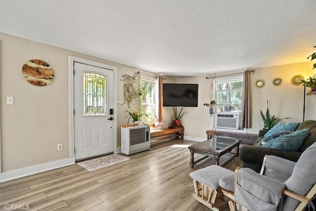 living room with a healthy amount of sunlight, light wood-type flooring, and cooling unit