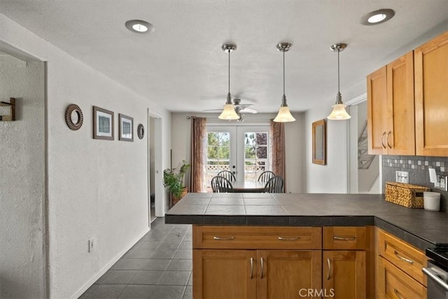 kitchen featuring ceiling fan, french doors, kitchen peninsula, decorative light fixtures, and decorative backsplash