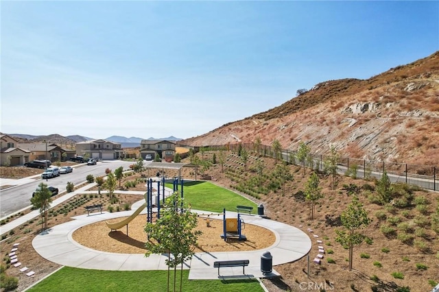 view of home's community featuring a lawn, a mountain view, and a playground