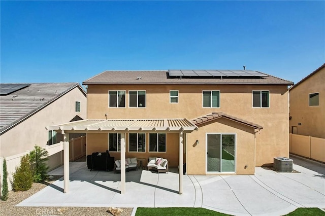 back of house featuring outdoor lounge area, solar panels, cooling unit, and a patio