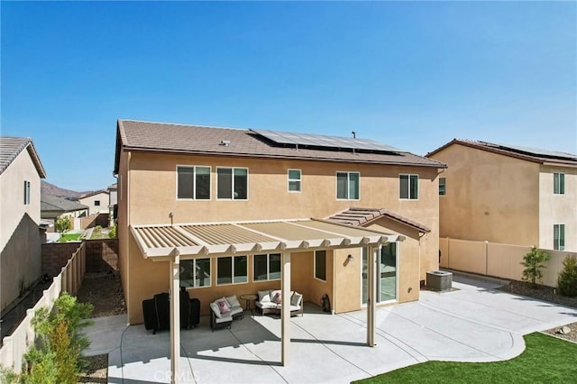 rear view of house featuring outdoor lounge area, central AC, a patio, and solar panels