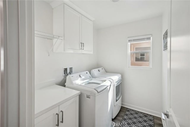 clothes washing area with cabinets, dark hardwood / wood-style floors, and washer and dryer