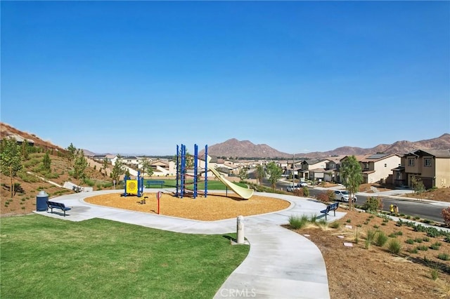 view of jungle gym with a mountain view and a yard