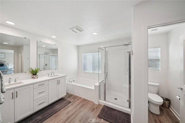 full bathroom featuring toilet, vanity, independent shower and bath, and hardwood / wood-style flooring