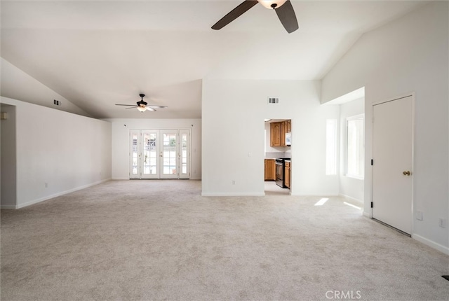 unfurnished living room with vaulted ceiling, light carpet, ceiling fan, and french doors