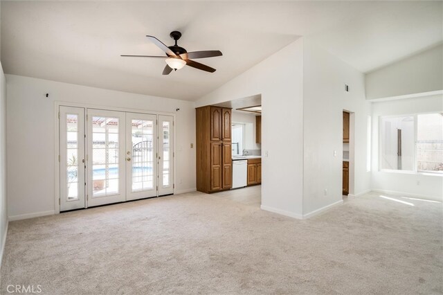 unfurnished living room featuring light carpet, a wealth of natural light, ceiling fan, and french doors