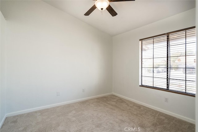 empty room featuring lofted ceiling, ceiling fan, and light colored carpet